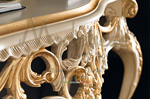 Up-close picture of hand carved wood details in lacquered ivory and gold leaf by Modenese Luxury Interiors